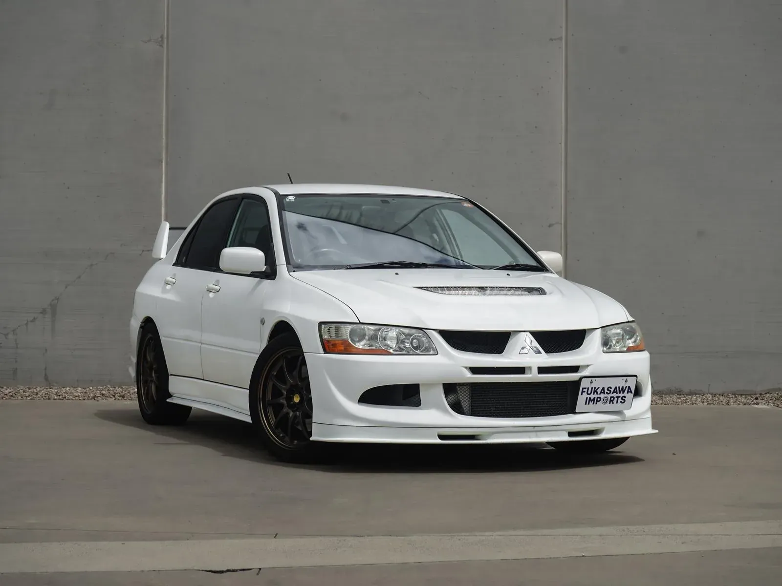 White Mitsubishi Lancer Evolution VIII GSR imported by Fukasawa Car Imports, front three-quarter studio shot