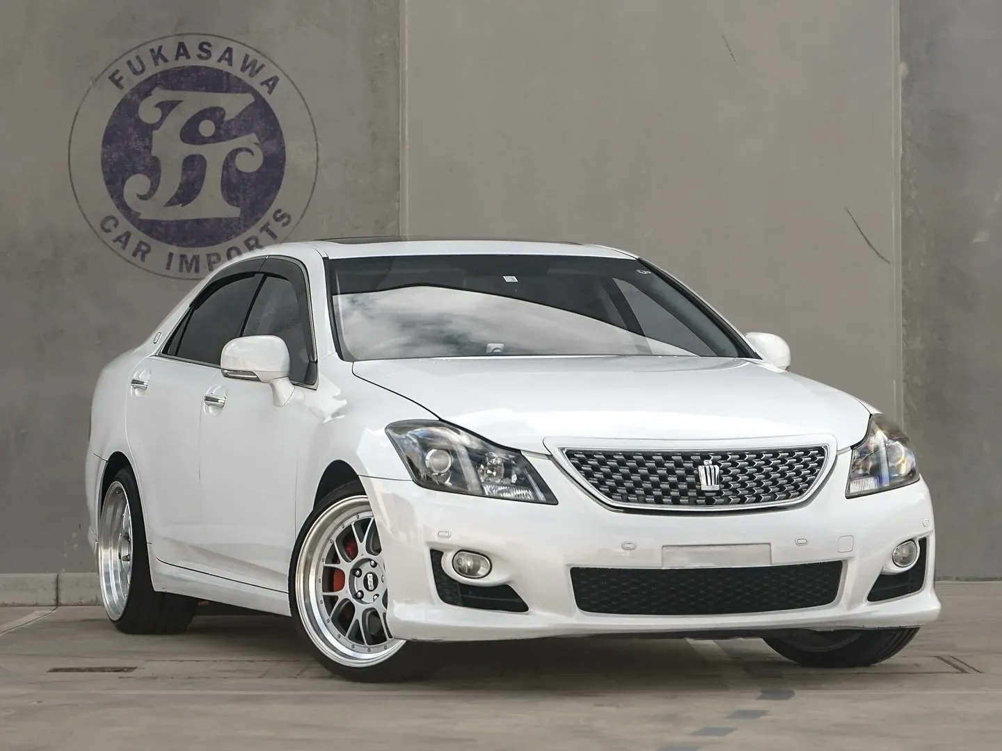White Toyota Crown Athlete GRS204 imported from Japan by Fukasawa Car Imports, front three-quarter view
