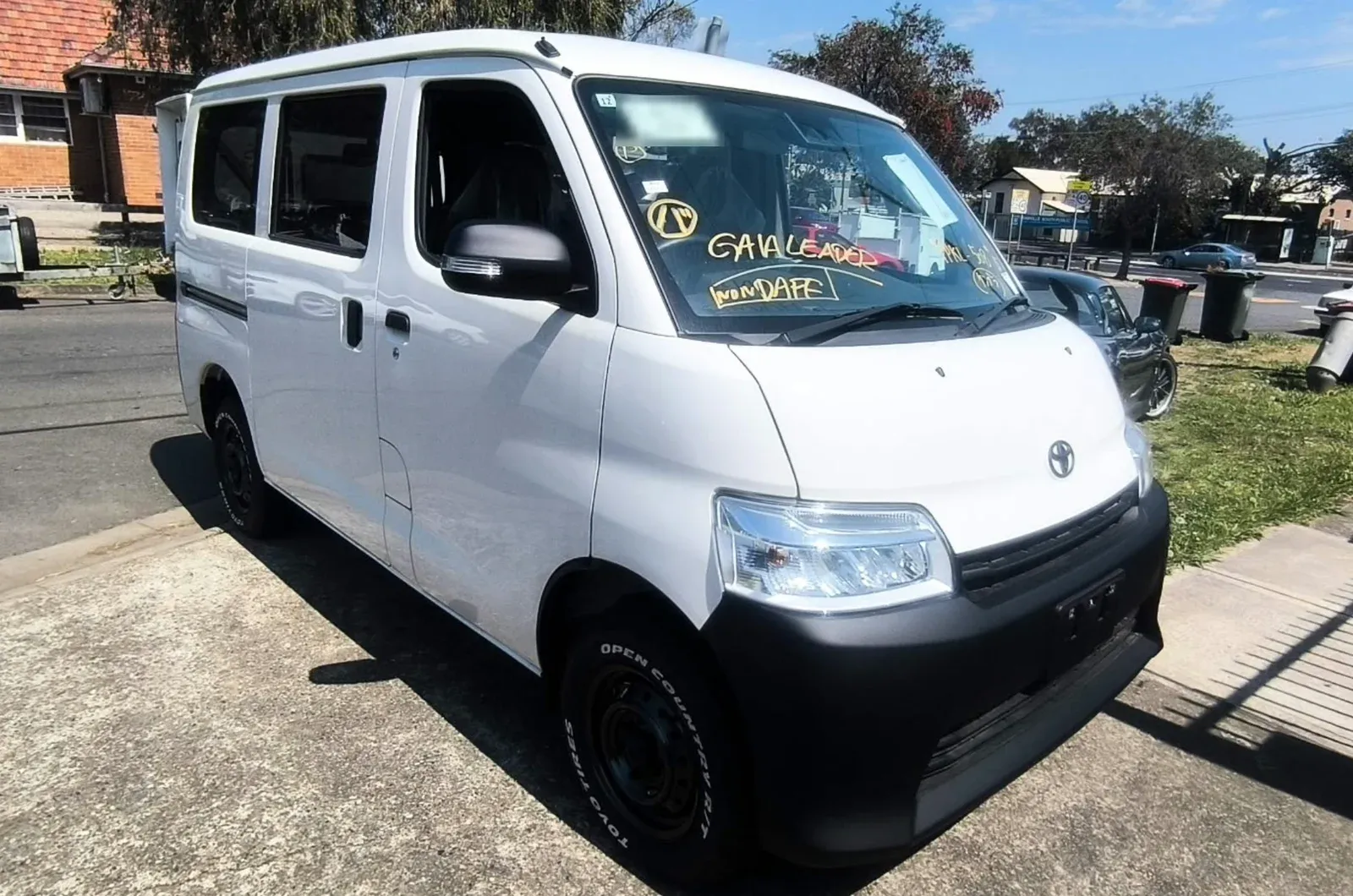 White Toyota TownAce van newly arrived from Japan, with shipping markings on the windscreen