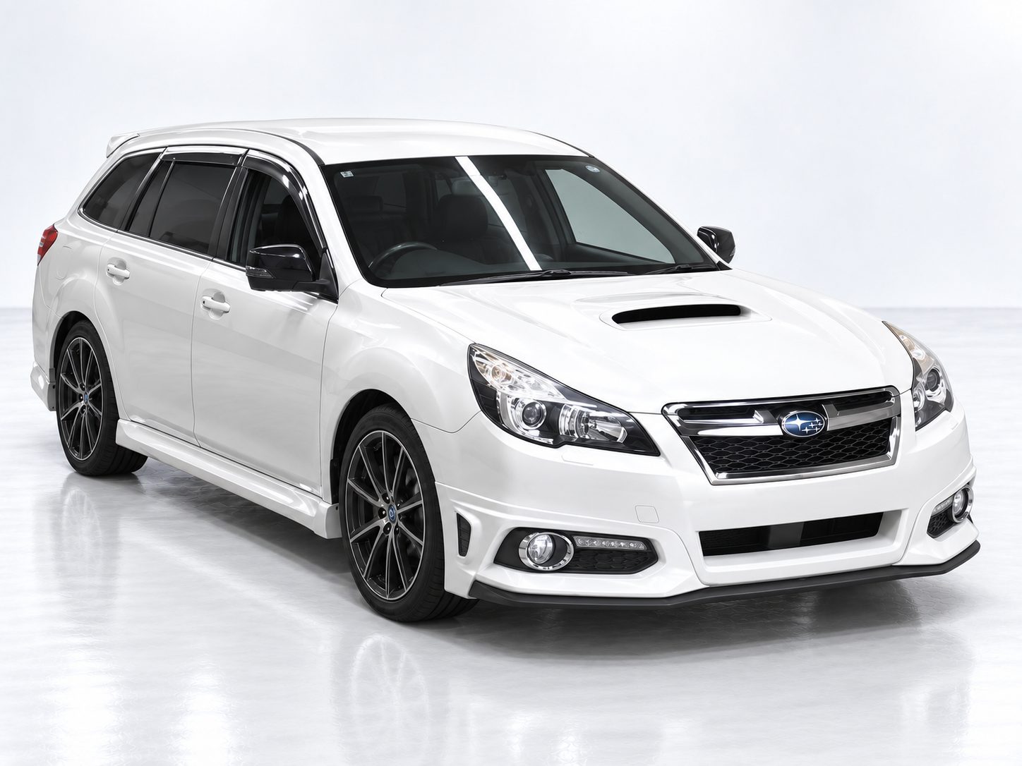 White Subaru Legacy Wagon BRG with dark alloy wheels, front three-quarter studio shot